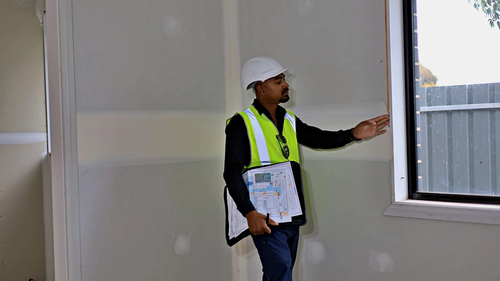 Imon Hussain, Registered Building Supervisor at Maverick Builds, reviewing plans on an Adelaide residential project